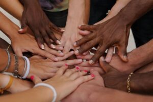 A close up image of a group of hands huddled together.